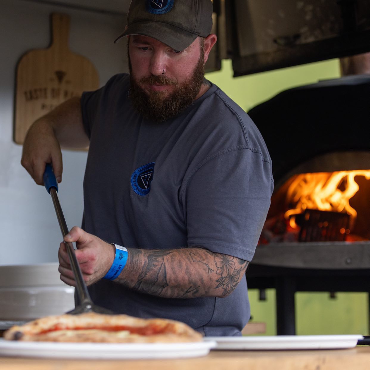 Darren cooking a fresh pizza next to the wood-fired oven